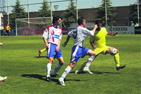 El villalbino César protege el balón ante la presión del majariego Melgar   (Foto:  RICARDO MIGUEL PEÑA)