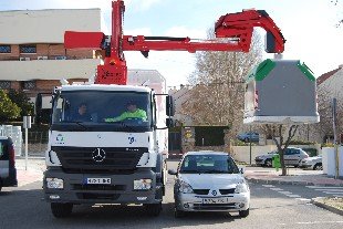 El brazo mecánico del camión salva un coche para elevar el contenedor (Foto: E. P.)