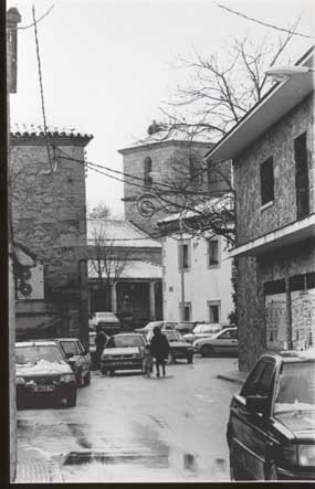 El invierno viste de blanco Villalba Pueblo.-Imagen puramente navideña tomada el día 6 de enero de 2001. Al fondo la iglesia de Nuestra Señora del Enebral, con nido de cigüeña incluido, cubierta por una pequeña capa de nieve, y en primer plano algunos viandantes que, desafiando el frío, se dirigían a la panadería de Serafín mezclándose con los vehículos más madrugadores que circulaban por la avenida de la Libertad.