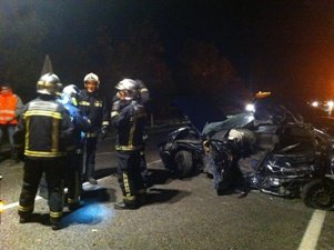 Efectivos de Bomberos junto al turismo siniestrado (Foto: Comunidad de Madrid)