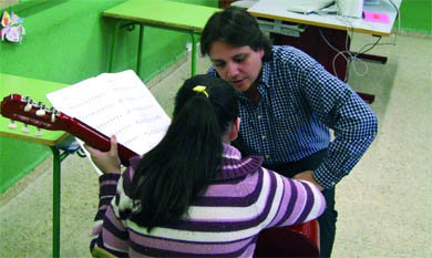 Un profesor, en clase de guitarra con una de las alumnas del centro  (Foto: ARCHIVO)